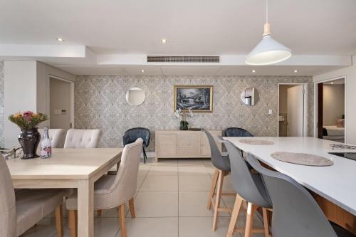 een keuken en eetkamer met een tafel en stoelen bij Eden on the Bay 167 by HostAgents in Bloubergstrand