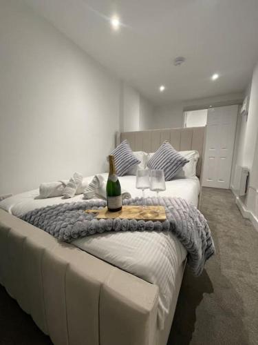 ein großes weißes Bett mit einer Flasche Wein drauf in der Unterkunft (NEW) Poppy's place - 10 minute drive from York in Skelton