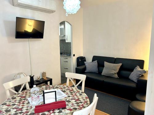 a living room with a black couch and a table at Apartment carrer d'Olesa in Barcelona