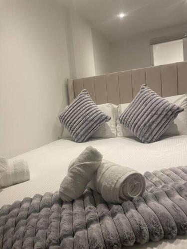 Una cama con manta y almohadas. en (NEW) Poppy's place - 10 minute drive from York en Skelton