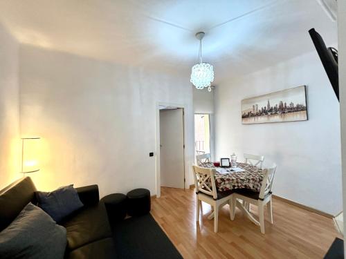 ein Wohnzimmer mit einem Sofa und einem Esstisch in der Unterkunft Apartment carrer d'Olesa in Barcelona