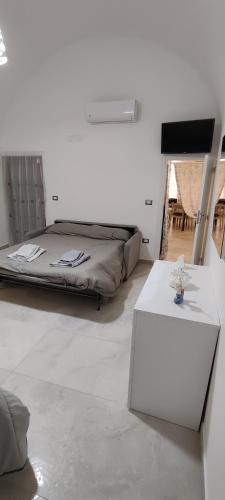 a bedroom with a bed and a white table at Maison de Marie in Trani