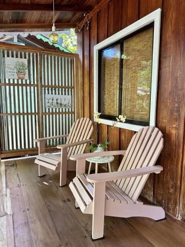 two chairs and a table on the porch of a cabin at Caribbean Flow in Puerto Viejo