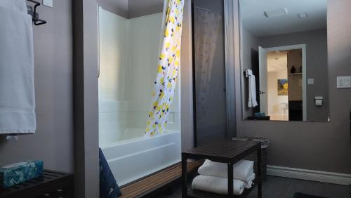 a bathroom with a shower and a table and a tub at Private trendy studio with fireplace in Ottawa