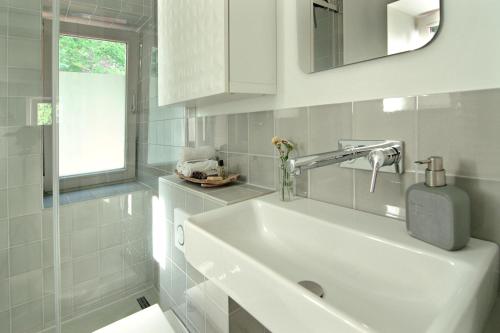 a white bathroom with a sink and a window at Elbblick in Hamburg