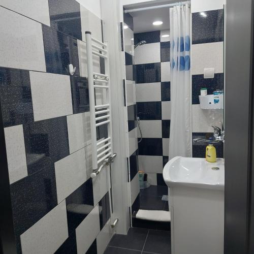 a bathroom with a black and white tile wall at Dayana Home in Râmnicu Vâlcea