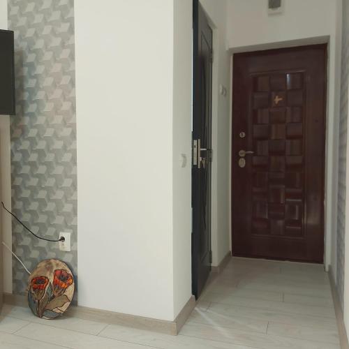 un pasillo con una puerta y un jarrón en el suelo en Dayana Home en Râmnicu Vâlcea