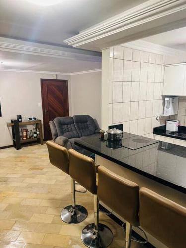 a kitchen with a counter and chairs in a room at Melhor localização de Floripa. in Florianópolis