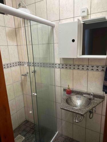 y baño con lavabo y ducha acristalada. en Melhor localização de Floripa. en Florianópolis