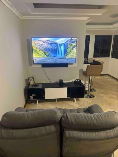 a living room with a couch and a flat screen tv at Melhor localização de Floripa. in Florianópolis