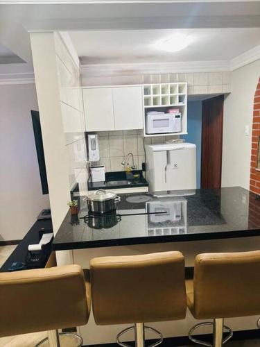 a kitchen with a counter and some chairs in it at Melhor localização de Floripa. in Florianópolis