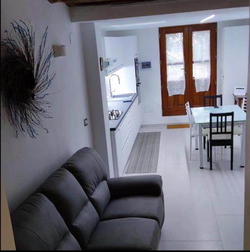Triei的住宿－Appartamento Su Piricocco - La casa dei ricordi，带沙发的客厅和带桌子的厨房