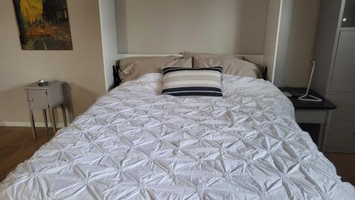 - un lit blanc avec un oreiller dans l'établissement Private trendy studio with fireplace, à Ottawa