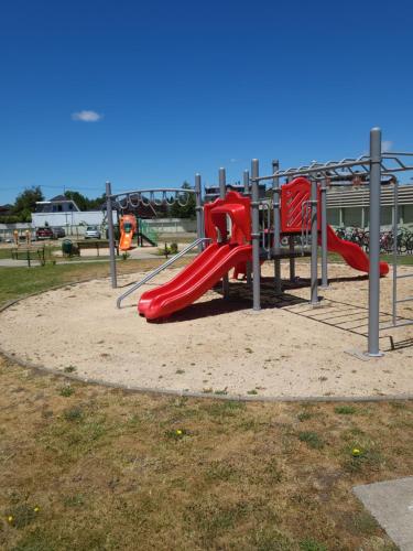 a playground with a red slide in a park at Departamento Krahmer Valdivia in Valdivia