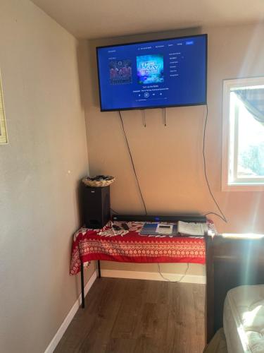 a room with a bench with a tv on the wall at The view in kau in Hawaiian Ocean View