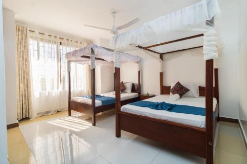a bedroom with two bunk beds with blue sheets at 3 bedroom Nyali apartment in Mombasa