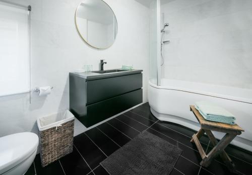 y baño con lavabo, bañera y espejo. en Kokerelle vakantiewoningen, en Maarkedal