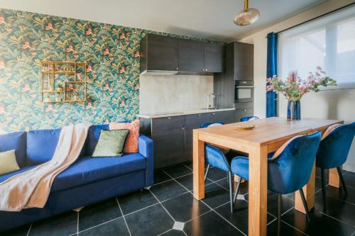 a living room with a blue couch and a wooden table at Kokerelle vakantiewoningen in Maarkedal