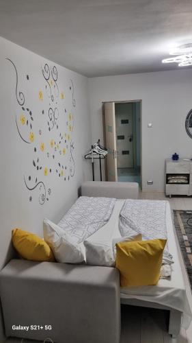 1 cama con almohadas amarillas en un dormitorio en La Tanti Bobi, en Lupeni