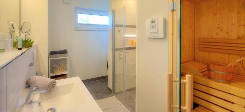 a bathroom with a shower and a white sink at Ferienwohnung Justus in Ostseebad Karlshagen
