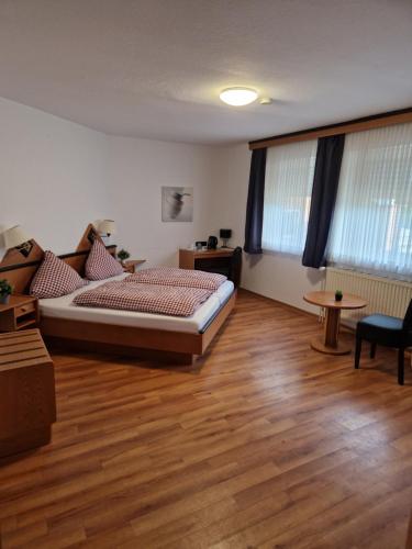 Schlafzimmer mit einem Bett und Holzboden in der Unterkunft Sporthotel Papenburg in Papenburg