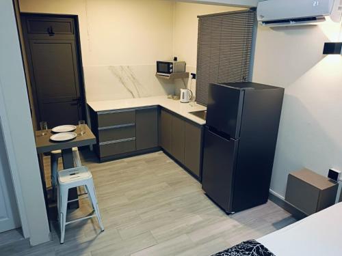 eine kleine Küche mit einem schwarzen Kühlschrank und einem Tisch in der Unterkunft VH Studios in Flic-en-Flac
