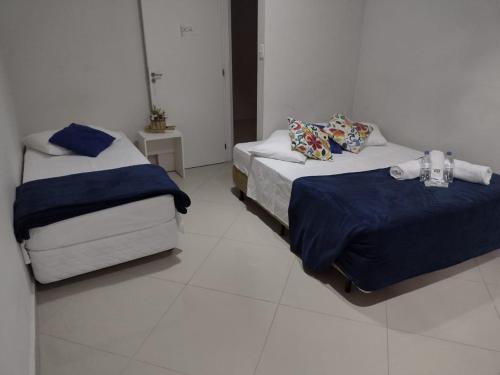 um quarto com 2 camas e um piso branco em Pousada TOP em Mairiporã