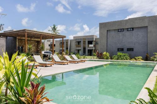 - une piscine avec des chaises longues à côté d'un bâtiment dans l'établissement Apto relaxante próximo a Praia do Patacho CVPE102, à Porto de Pedras