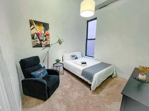een slaapkamer met een bed, een stoel en een raam bij McCormick Place 420 friendly 2br/2ba with optional parking for up to 6 guests in Chicago