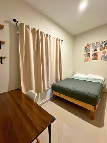 a small bedroom with a bed and a table at Condominio en Lomas de Mazatlán in Mazatlán