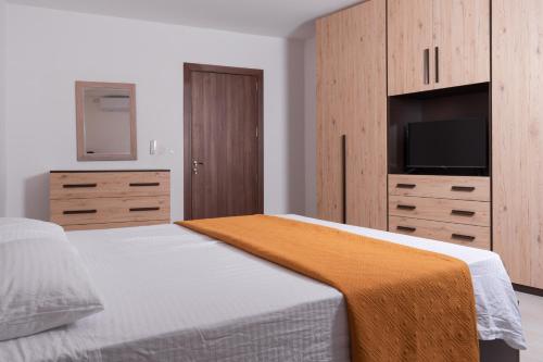 a bedroom with a bed with a television and a dresser at Azure FOUR in Żurrieq