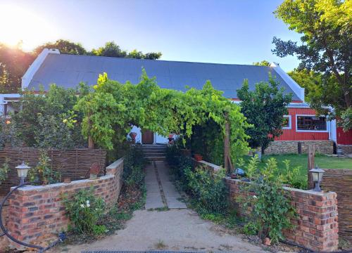 a garden with an arch and a brick wall at Goedgeloof Farm Stay in Barrydale