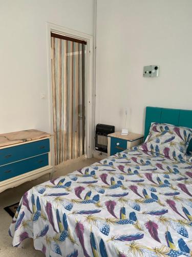 sypialnia z łóżkiem, komodą i drzwiami w obiekcie Résidence sassi w mieście Nabul