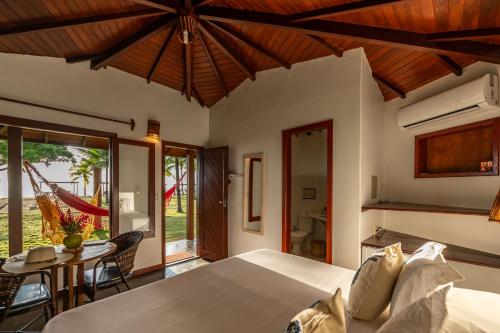 a bedroom with a bed and a table at Pousada Lagoa do Cassange in Marau