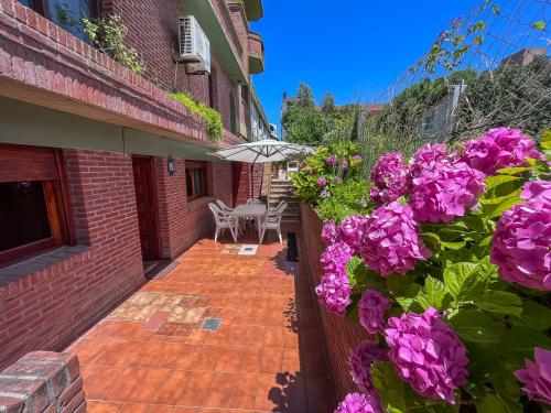 a patio with purple flowers on a brick building at Hotel Olimpia in Ostende