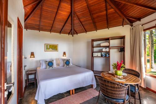 1 dormitorio en una villa con cama y mesa en Pousada Lagoa do Cassange, en Maraú