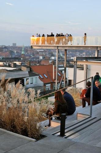 a group of people sitting on a balcony overlooking a city at AArhus 115 in Aarhus