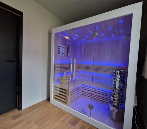 y baño con ducha con luces azules. en luxe vakantiehuisje - sauna - natuur - strand en Ewijk