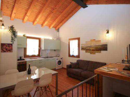 eine Küche und ein Wohnzimmer mit einem Sofa und einem Tisch in der Unterkunft DOMUS JESSICA in Campea