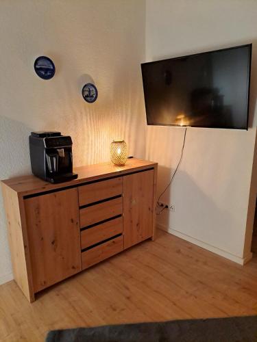 a flat screen tv on a wall with a wooden cabinet at Ferienwohnung Rheinsonne in Boppard