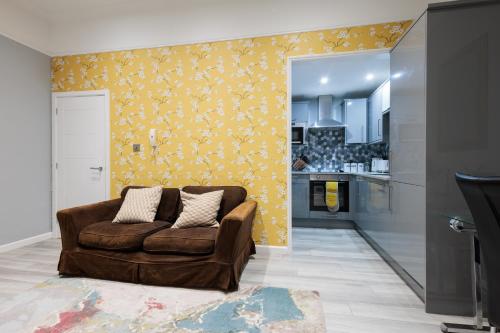 uma sala de estar com um sofá castanho e uma cozinha em Durley Gardens, by the Beach em Bournemouth