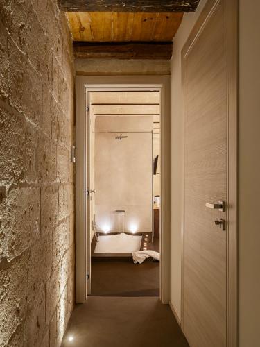 a hallway leading to a bedroom with a bed at Hydria Rooms in Matera