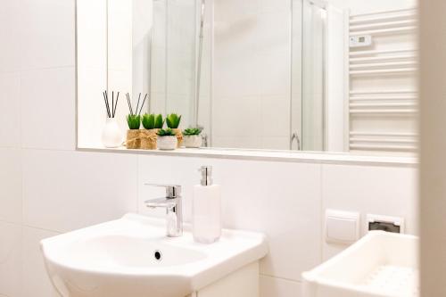 a white bathroom with a sink and a mirror at Apartament 3 in Polanica-Zdrój