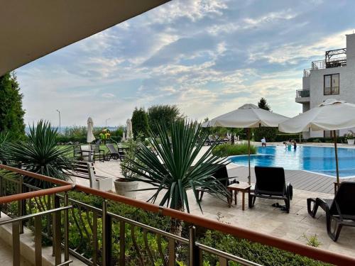 una vista di una piscina con sedie e ombrelloni di Diamond Beach Garden Apartment a Burgas