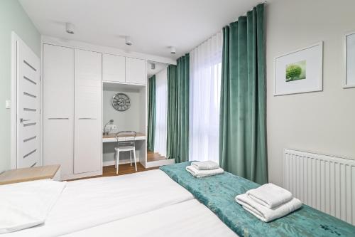 - une chambre avec 2 lits et un bureau dans l'établissement LTC Apartments Ujejskiego, à Gdynia