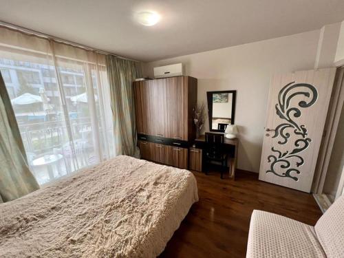 una camera da letto con un letto, una finestra e una scrivania di Diamond Beach Garden Apartment a Burgas