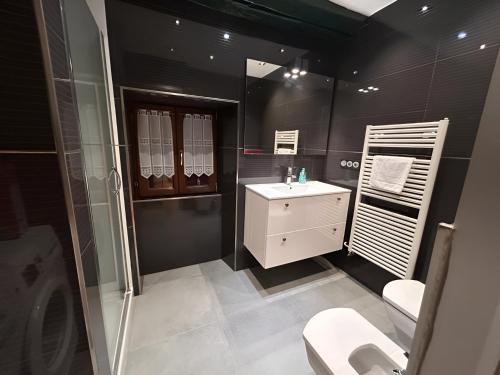 een zwarte badkamer met een wastafel en een toilet bij Apto ElizaG-1 in Lesaka