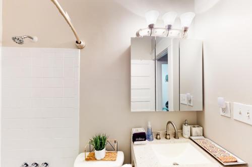 ein Bad mit einem Waschbecken und einem Spiegel in der Unterkunft Luxury on Piedmont in Atlanta