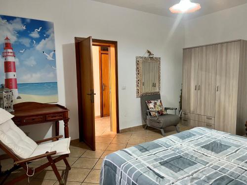 een slaapkamer met een bed, een bureau en een rode vuurtoren bij Le case di Helga in Budoni