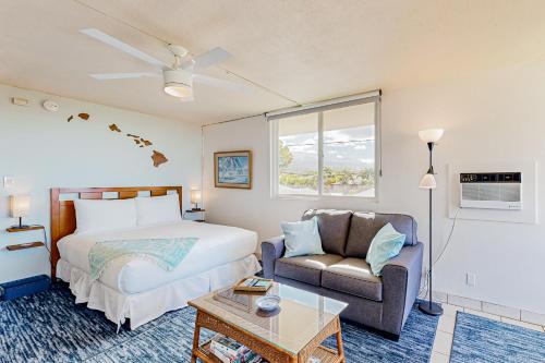 a bedroom with a bed and a couch and a chair at Hale Li'ili'i at Keawakapu #201 in Wailea